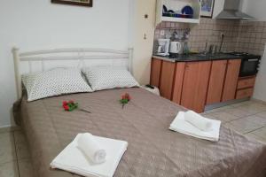 巴特斯欧LORENTZIA ROOM的一张带两个白色毛巾和红色鲜花的床