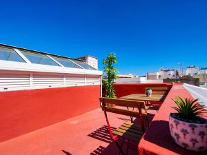 大加那利岛拉斯帕尔马斯Alma Canaria Apartments & Rooms的阳台设有长凳和屋顶桌子。