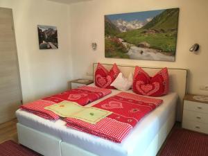 Sankt Johann im SaggautalGästehaus Schmid的一间卧室配有红色和白色枕头的床