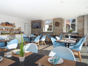 AldingenHotel das Q的一间配备有桌子和蓝色椅子的用餐室