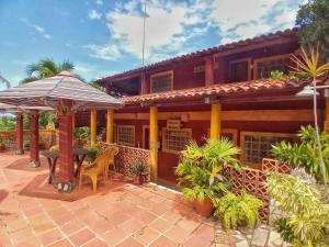 雅克南Casa da Lua的房屋设有带桌子和遮阳伞的庭院