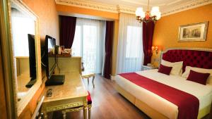 伊斯坦布尔Hotel Gritti Pera & Spa的酒店客房,配有床和电视