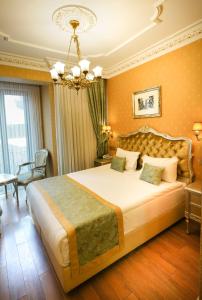 伊斯坦布尔Hotel Gritti Pera & Spa的一间卧室配有一张大床和一个吊灯。