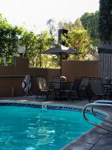 阿罕布拉GreenTree Inn & Suites Los Angeles - Alhambra - Pasadena的一个带桌椅和遮阳伞的游泳池