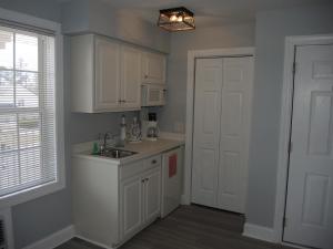 卡拉巴什1408L home的厨房配有白色橱柜、水槽和门