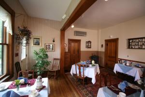 拉德洛The Governor's Inn的一间用餐室,配有2张带白色桌布的桌子