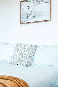 扬巴The Stella的一张带枕头的床和墙上的照片