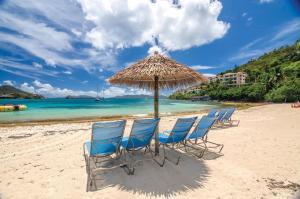 弗雷德达尔Margaritaville Vacation Club by Wyndham - St Thomas的海滩上一把遮阳伞下的椅子