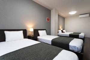 大阪Hotel Piacere NAMBA的酒店客房设有两张床和两盏灯。