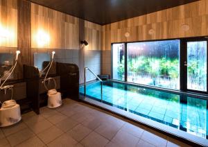 高石市HOTEL ROUTE-INN Osaka Takaishi Hagoromo Ekimae的一个带大窗户的房间内的游泳池
