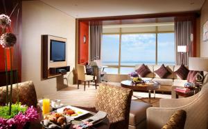 杭州杭州洲际酒店的带沙发的客厅和带电视的客房。