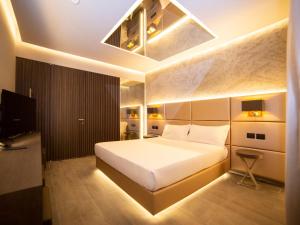 塞塔拉查理汽车旅店酒店的卧室配有一张白色大床和电视。