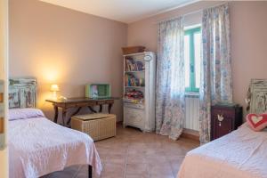 阿特里Casale Vittoria的一间卧室设有两张床、一张桌子和一个窗口