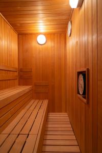 金泽Torifito Hotel & Pod Kanazawa的一间设有木镶板和墙上时钟的桑拿浴室