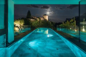 沃兰澄镜森林酒店的一座晚上的游泳池,后面是一座城堡