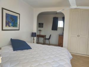 雷以桑布尔南方别墅的卧室配有一张白色大床和一张书桌