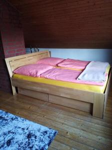 奥古斯都堡Ferienhaus Ullrich的木地板上的一张带粉红色床单的木床