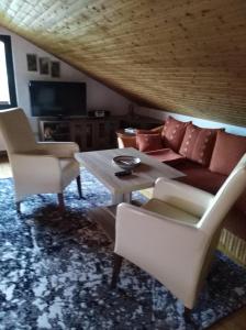 奥古斯都堡Ferienhaus Ullrich的客厅配有沙发、椅子和桌子