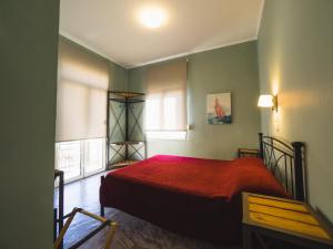 希俄斯Filoxenia Hotel的一间卧室设有红色的床和2个窗户。