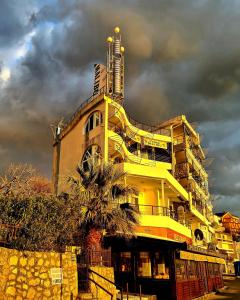 苏托莫雷马里布公寓的一座黄色的建筑,前面有棕榈树