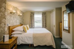 Little Langdale三夏尔斯旅馆的一间卧室设有一张床和一个窗口