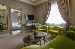 布加勒斯特Hotel Lido by Phoenicia的客厅配有沙发、椅子和桌子