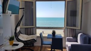 都拉斯Arteg Apartments - Full Sea View的一间带吊床的客厅,享有海滩美景
