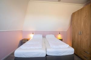 德瓦尔Nieuwlanderweg 69的小房间设有两张床和两盏灯