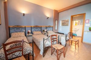 卢切拉Masseria Sant'Agapito的一间卧室配有三张床和一张桌子及椅子