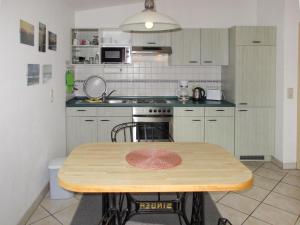 岑平Apartment Kornblume by Interhome的厨房配有木桌和炉灶。