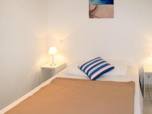比斯卡罗斯海滩Apartment Résidence Belle Dune - BPL331 by Interhome的一间卧室配有一张床,床上有条纹枕头
