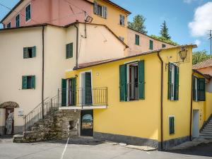 PantasinaHoliday Home Ca' da Prima Porta - VLO131 by Interhome的黄色和白色的建筑,设有绿色百叶窗