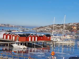 SkarvikSkärgårdsidyll på Björkö med gångavstånd till havet的码头,有红色的房子和水中的船只