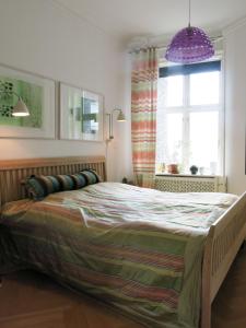 哥本哈根ApartmentInCopenhagen Apartment 1290的一间卧室配有一张大床和紫色灯