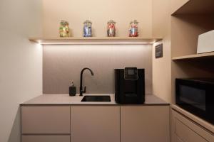 新加坡KINN Capsule的厨房配有水槽和台面上的咖啡壶