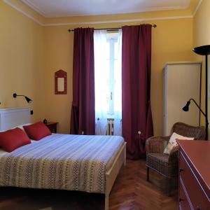 都灵阿尔玛克拉拉住宿加早餐酒店的一间卧室配有床和红色窗帘的窗户