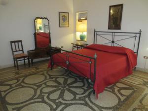 莱乌卡Villa Superior Vista mare的一间卧室配有红色的床、椅子和镜子