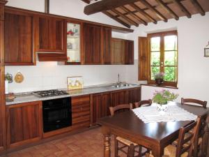 Sant' AlessioHoliday Home Renata by Interhome的厨房配有木制橱柜、餐桌和用餐室