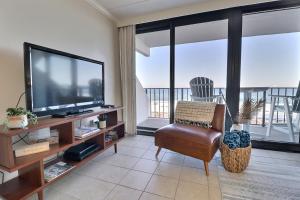 格尔夫海岸Island Winds East的客厅配有平面电视和椅子。