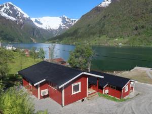 巴里斯川Holiday Home Raumelen - FJS018 by Interhome的红色小屋,后面有湖泊和山脉