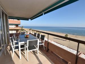 托里代巴拉Apartment Els Pins Atico by Interhome的俯瞰海滩的阳台配有桌椅