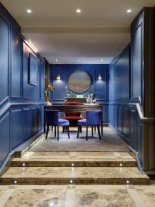 伦敦Flemings Mayfair - Small Luxury Hotel of the World的一间拥有蓝色墙壁和桌椅的用餐室