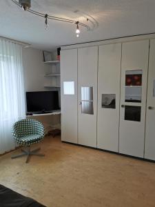 RudolfstettenFerienwohnung und B&B Chasa Janett的客厅配有大型白色橱柜和椅子
