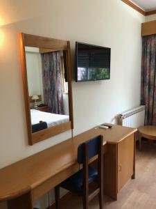 曼瓜尔迪HOTEL CRUZ DA MATA的客房设有书桌、镜子和床。