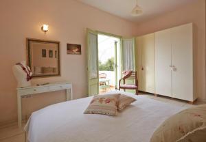 莫诺利索斯Flower and Crafts - The Eco Nature House的卧室配有一张带镜子的白色床和窗户。