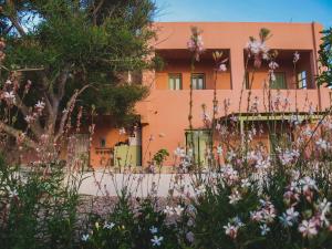 莫诺利索斯Flower and Crafts - The Eco Nature House的一座橘色房子前面有鲜花