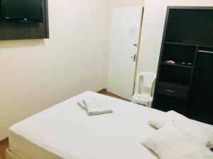 贝洛奥里藏特Hotel GMatos Belo Horizonte - By UP Hotel的一张白色的床,上面有眼镜