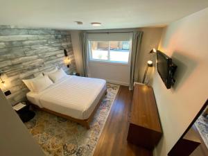 托菲诺玛克酒店的一间卧室配有一张床和一台电视