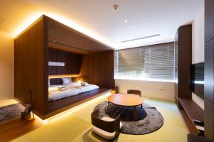 金泽Torifito Hotel & Pod Kanazawa的卧室配有一张床和一张桌子