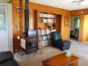 大堡礁岛Awesome View Cottage的客厅配有炉灶、椅子和书架